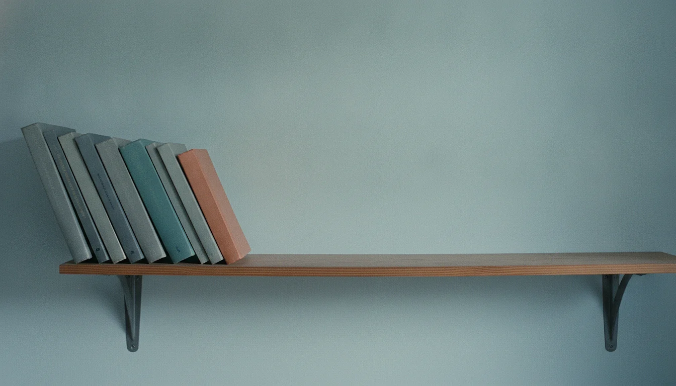A wooden bookshelf with a long empty gap where half the books were removed, the remaining row leaning into the space.